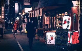 日本犯罪悬疑电影《深夜证人》剧照，侦探在霓虹灯闪烁的夜晚街道调查案件，色调昏暗紧张