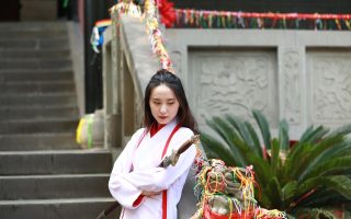 韩国历史古装电影《王朝秘史》剧照，宫廷场景中大臣跪拜，华丽服饰与宏大殿堂，色彩浓烈庄重