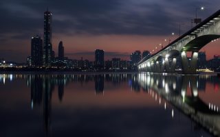 韩国爱情喜剧电影《首尔情书》剧照，男女主角在首尔街头相遇，背景有汉江和城市夜景，画面明亮温馨